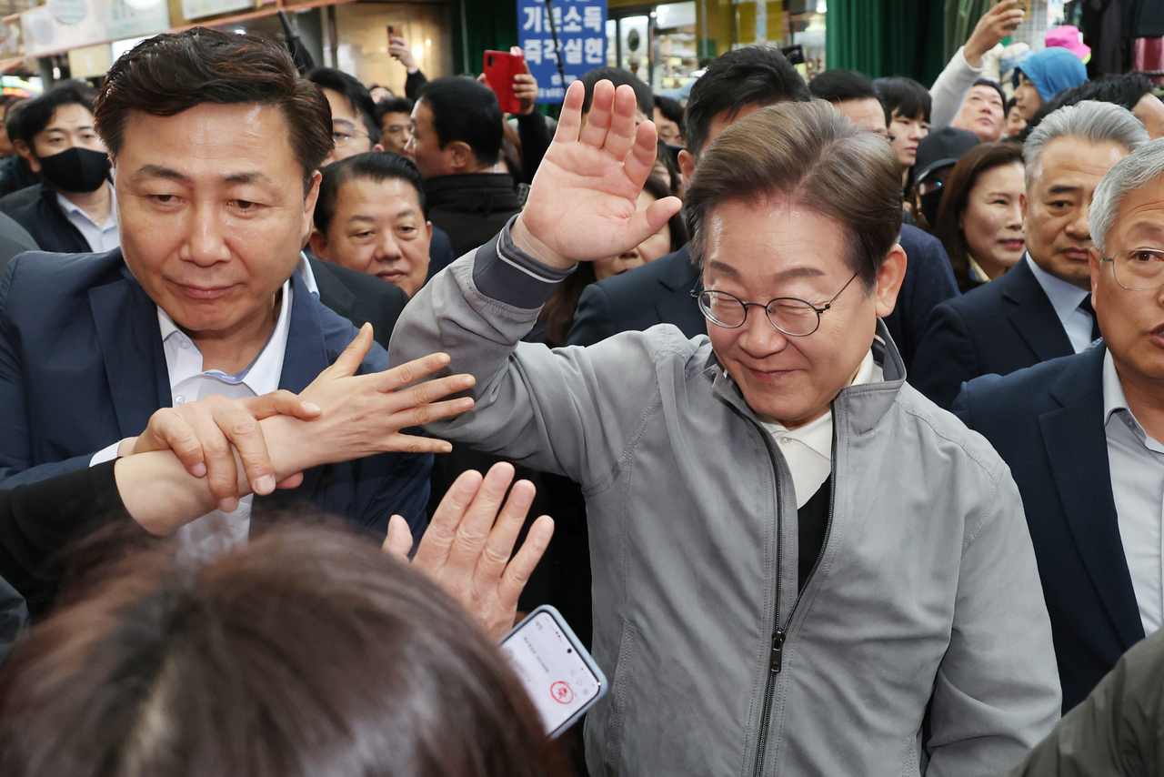 Lee Jae-myung, the presidential candidate of the Democratic Party, greets locals at a market in the eastern coastal city of Sokcho on May 3, 2025. (Yonhap)