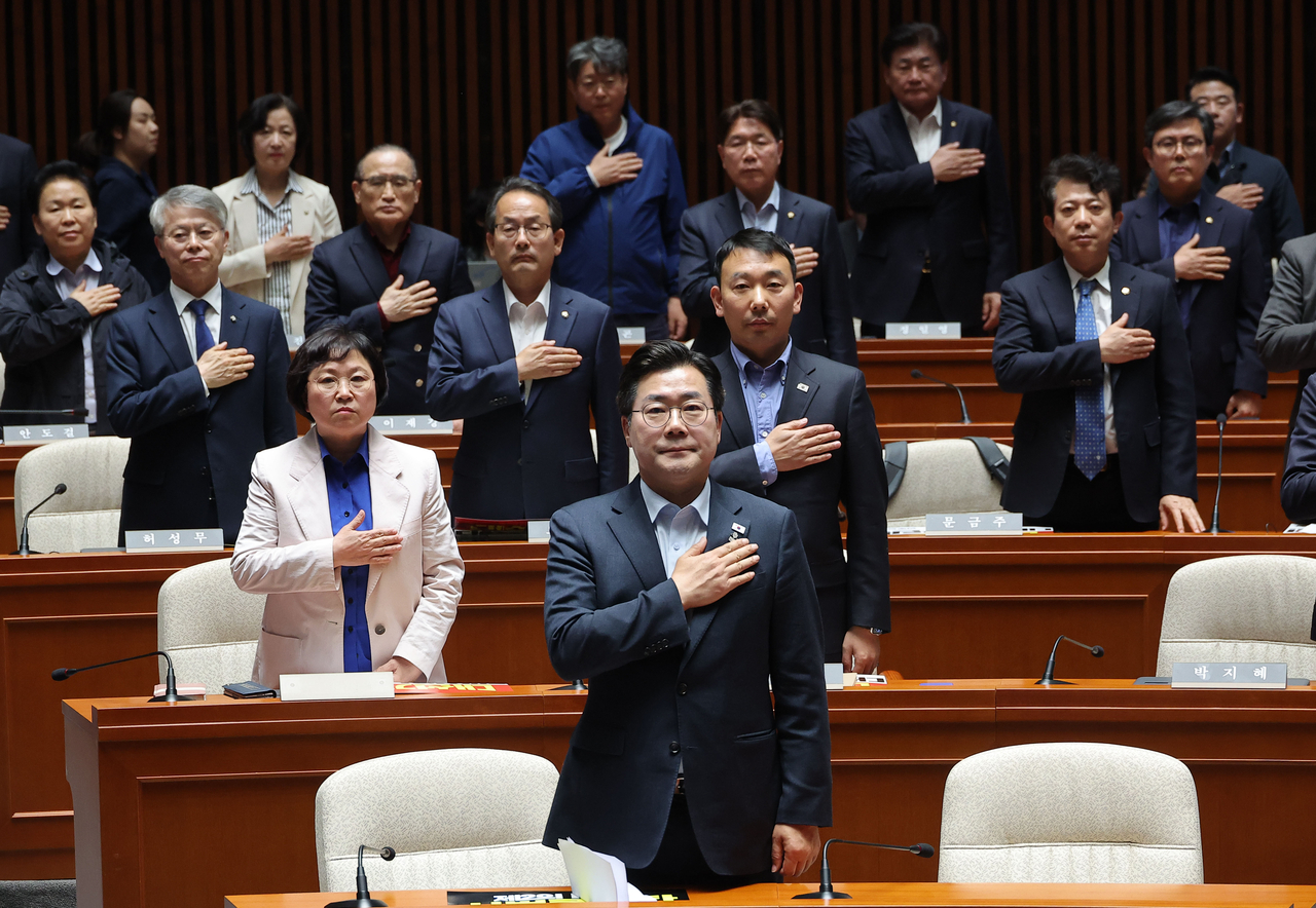 더불어민주당 박찬대 원내대표를 비롯한 의원들이 4일 국회에서 열린 긴급 의원총회에서 국기에 경례를 하고 있다. [연합]