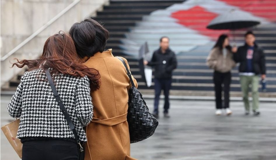 약한 비가 내리며 흐린 날씨를 보인 지난 달 16일, 서울 종로구 광화문 광장에서 시민들이 찬 바람에 몸을 움츠리고 있다. [연합]