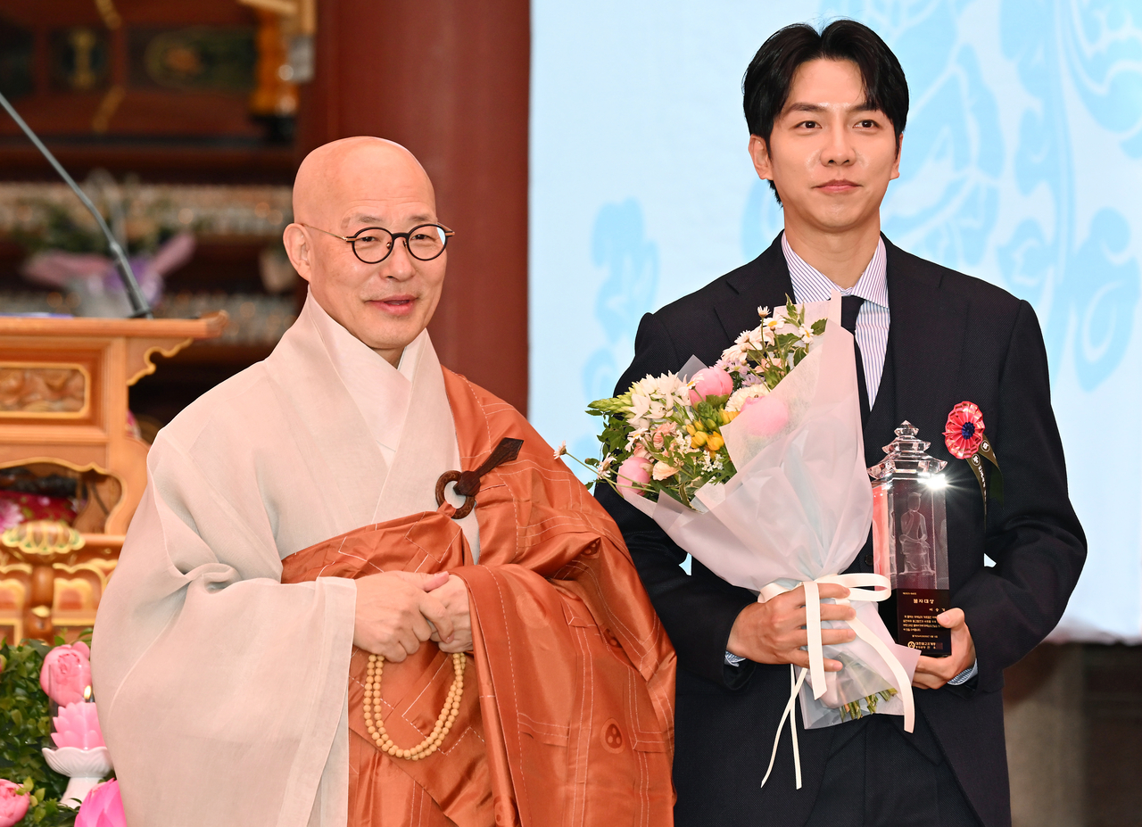 가수 이승기가 5일 서울 종로구 조계사에서 열린 불기 2569년 부처님오신날 봉축법요식에서 조계종 총무원장 진우스님으로부터 2025 불자대상을 수상한 뒤 기념촬영을 하고 있다. [연합]