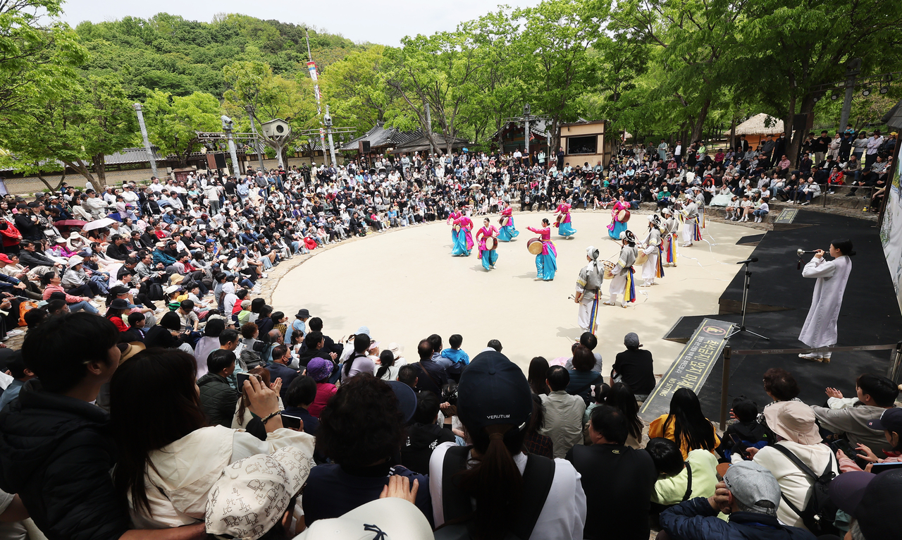 A large audience fills the Korean Folk Village in Yongin on Tuesday afternoon, watching cultural performances to mark the end of the long May holiday. (Yonhap)