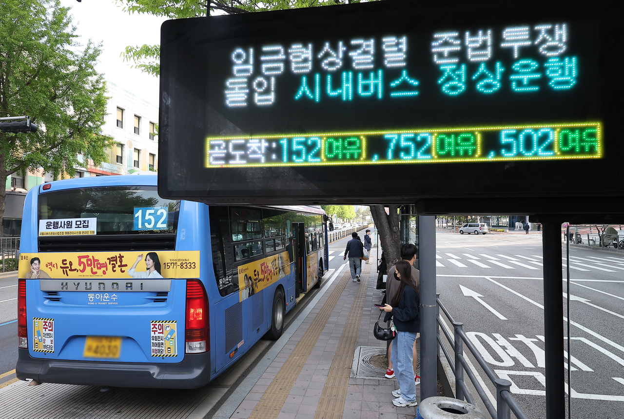 An electronic panel at a bus stop in central Seoul notifies passengers of a "work-to-rule" protest by unionized bus drivers, April 30. (Yonhap)