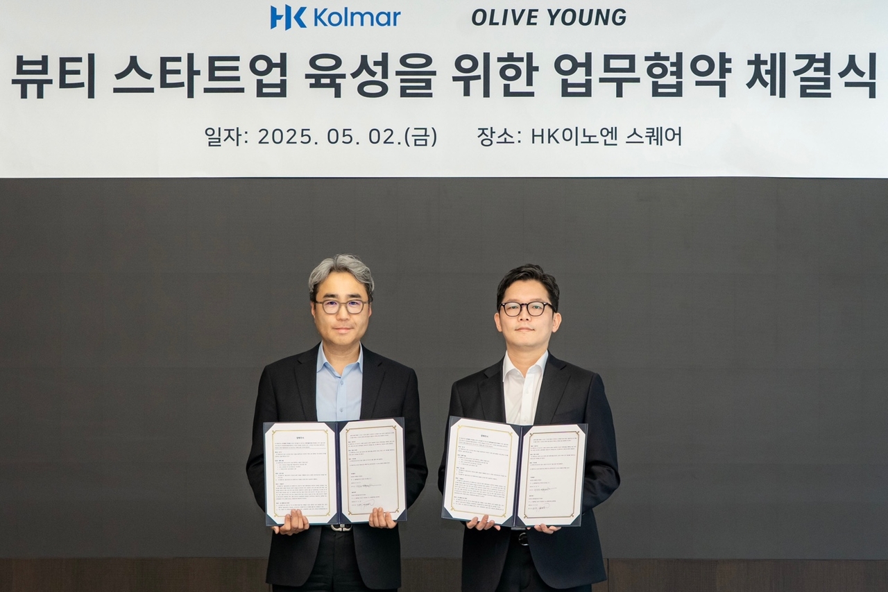 Huh Hyun-haeng, Kolmar Korea's head of business planning (left) and Jang Ji-min, CJ Olive Young's head of business support, pose for a photo after signing a business agreement on Friday. (Olive Young)