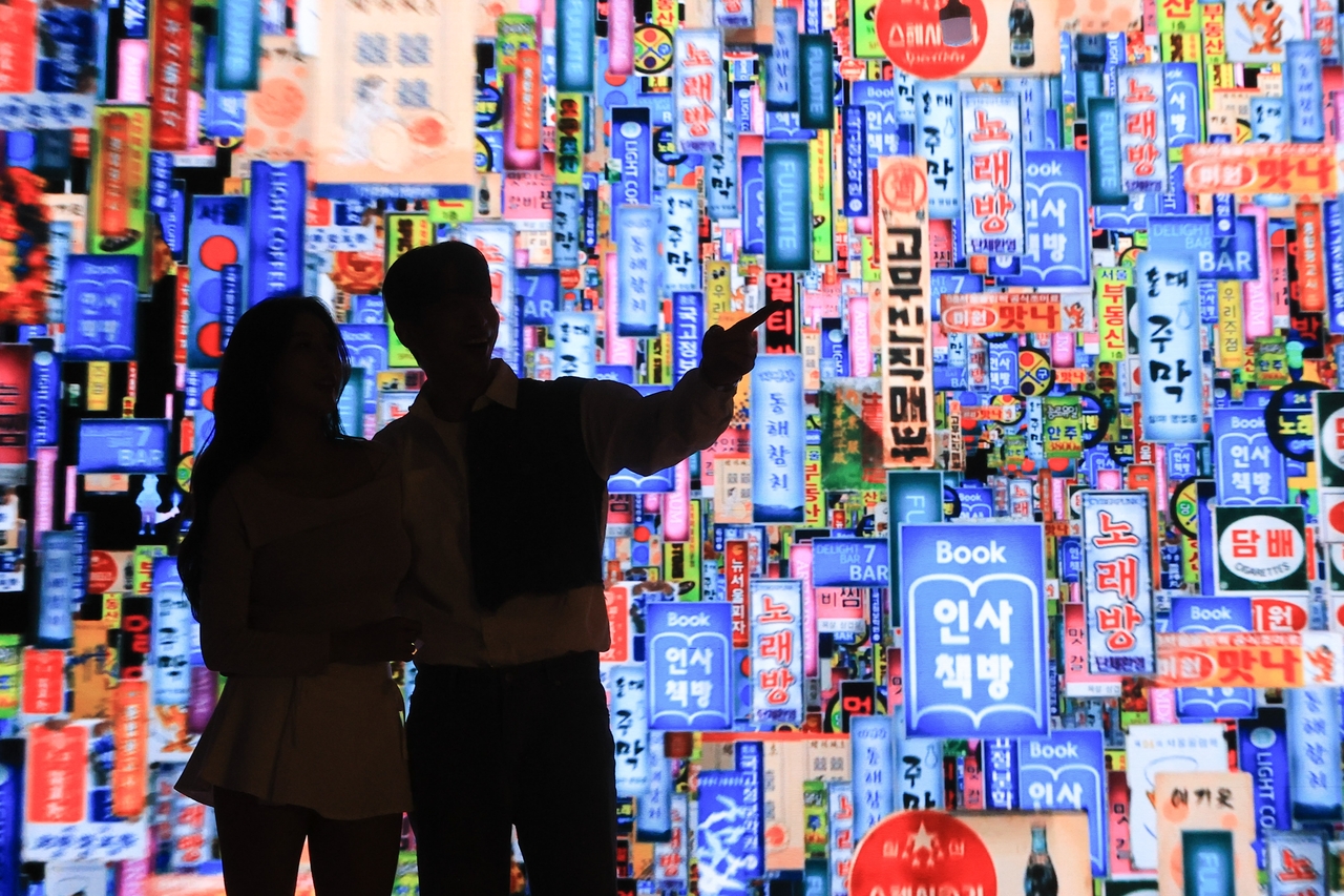 A digital wall at Delight Seoul 2025 displays hundreds of animated Korean storefront signs, recreating Seoul’s dense commercial streetscape. (Yonhap)