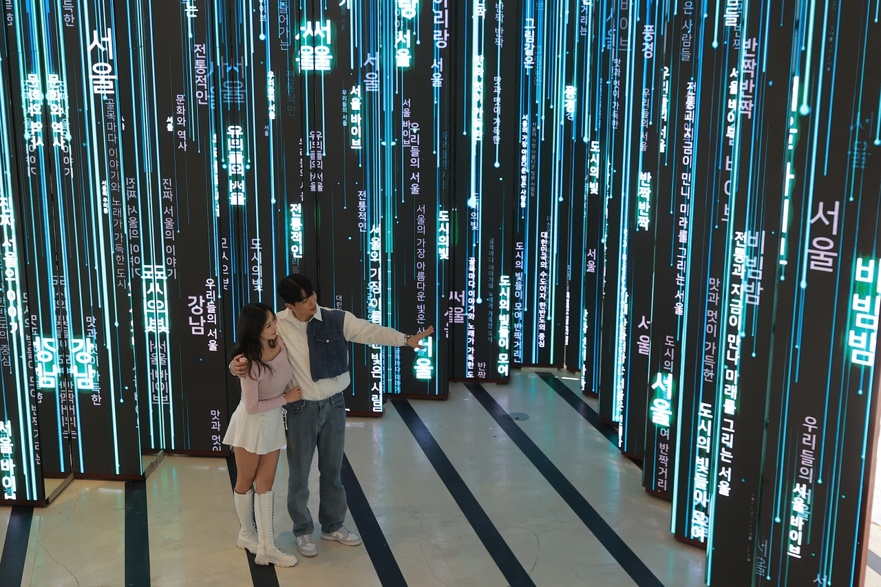 Vertical LED panels stream cascading Korean text in a tunnel-like media installation. (Yonhap)