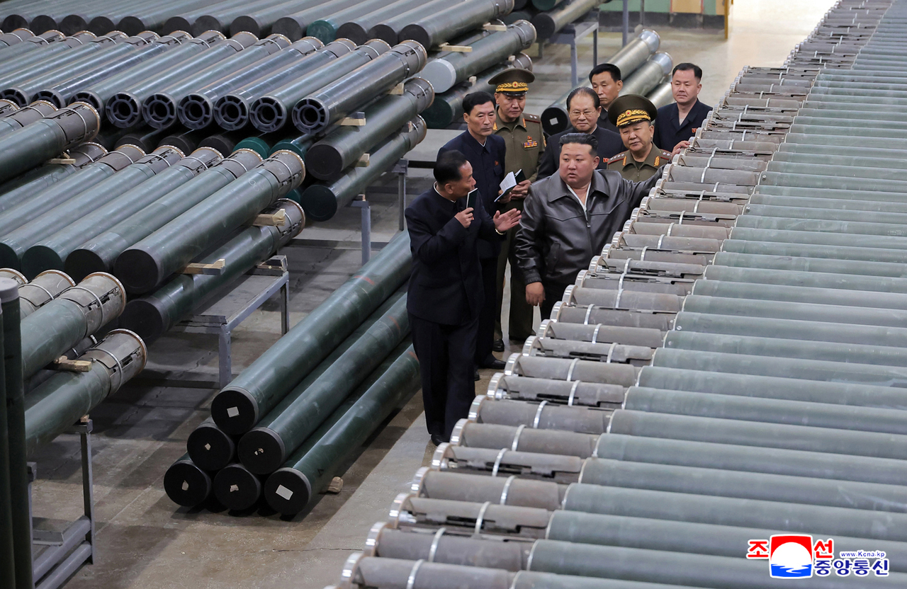 North Korean leader Kim Jong-un, wearing a black leather jacket, looks at shells during a visit to a munitions factory, in this undated photo released Wednesday by the North’s official Korean Central News Agency. The name and location of the factory were not disclosed. (Yonhap)