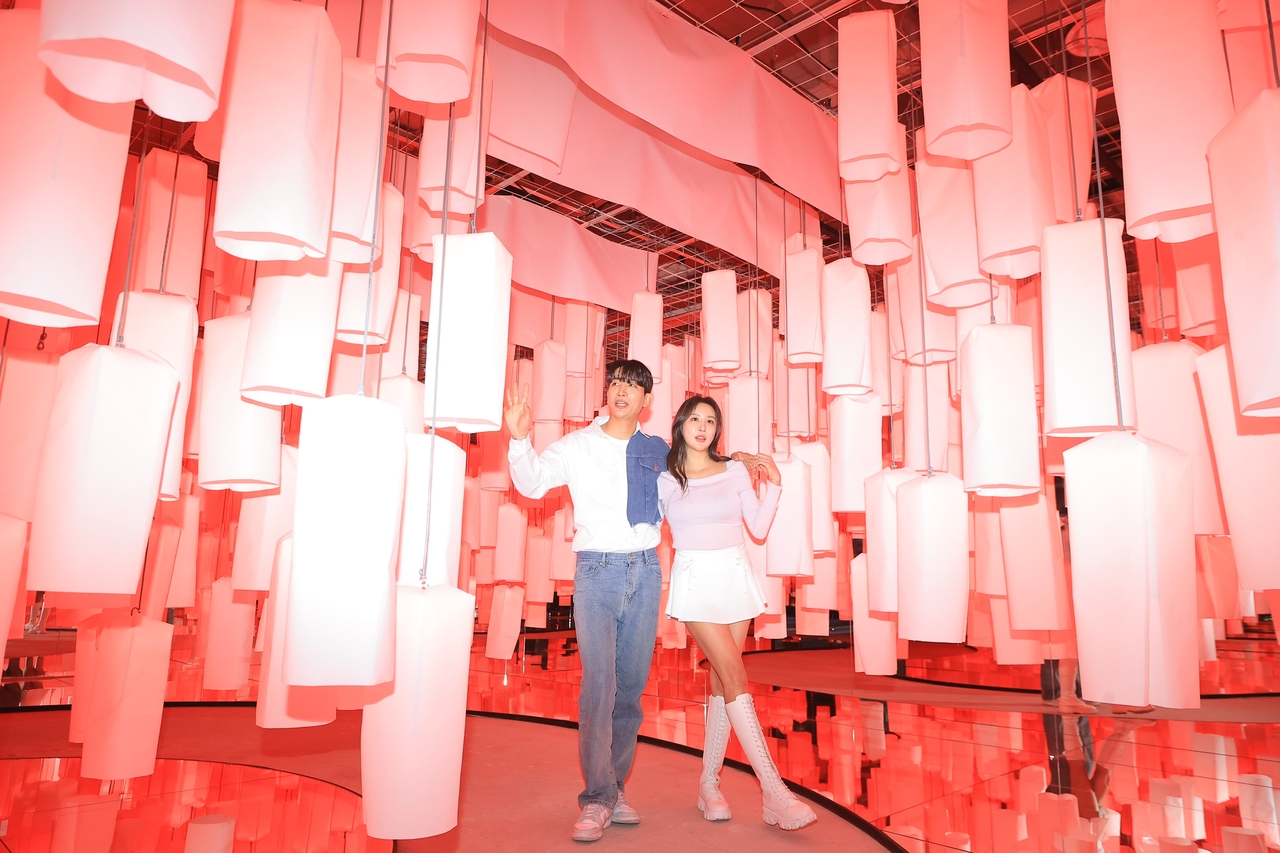 An installation of suspended pink lanterns creates a glowing, immersive pathway. (Yonhap)