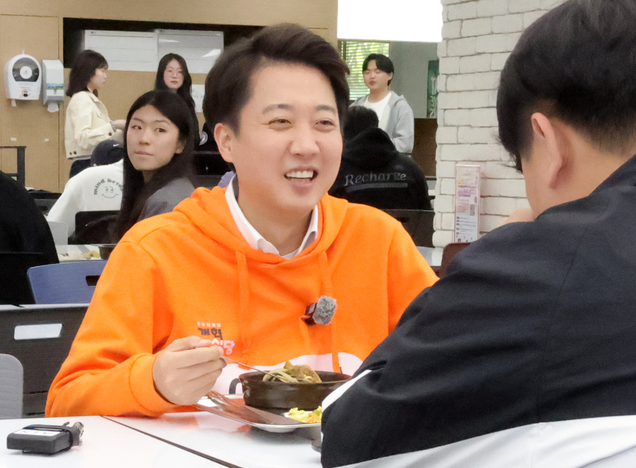 The New Reform Party's presidential candidate Rep. Lee Jun-seok speaks with a student while having lunch at Korea Aerospace University in Goyang, Gyeonggi Province, April 29. (Yonhap)