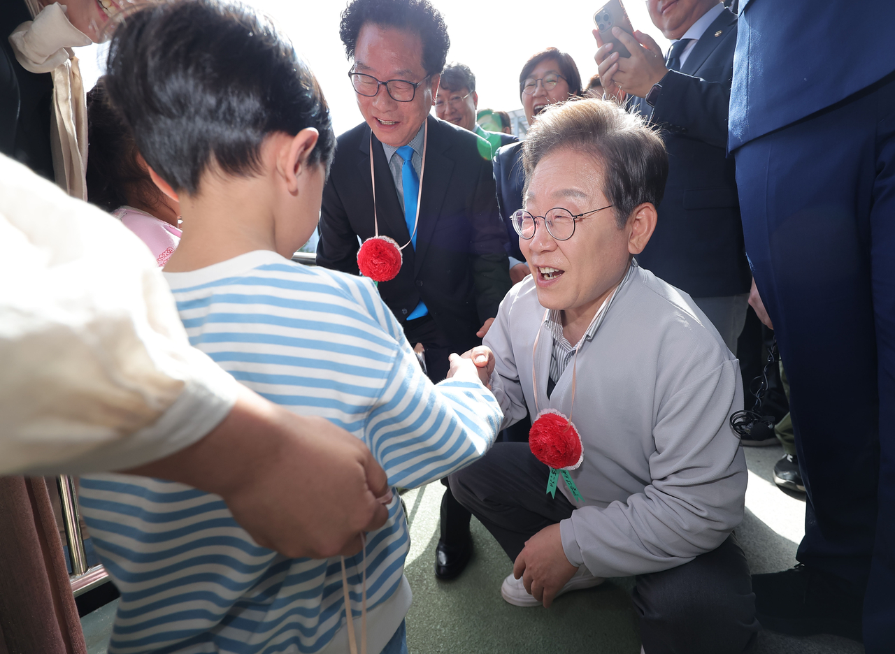 더불어민주당 이재명 대선 후보가 7일 전북 익산시 대한노인회 익산시지회에서 열린 노인회 간담회에 참석해 어린이로부터 카네이션 목걸이를 받고 있다. [연합뉴스]