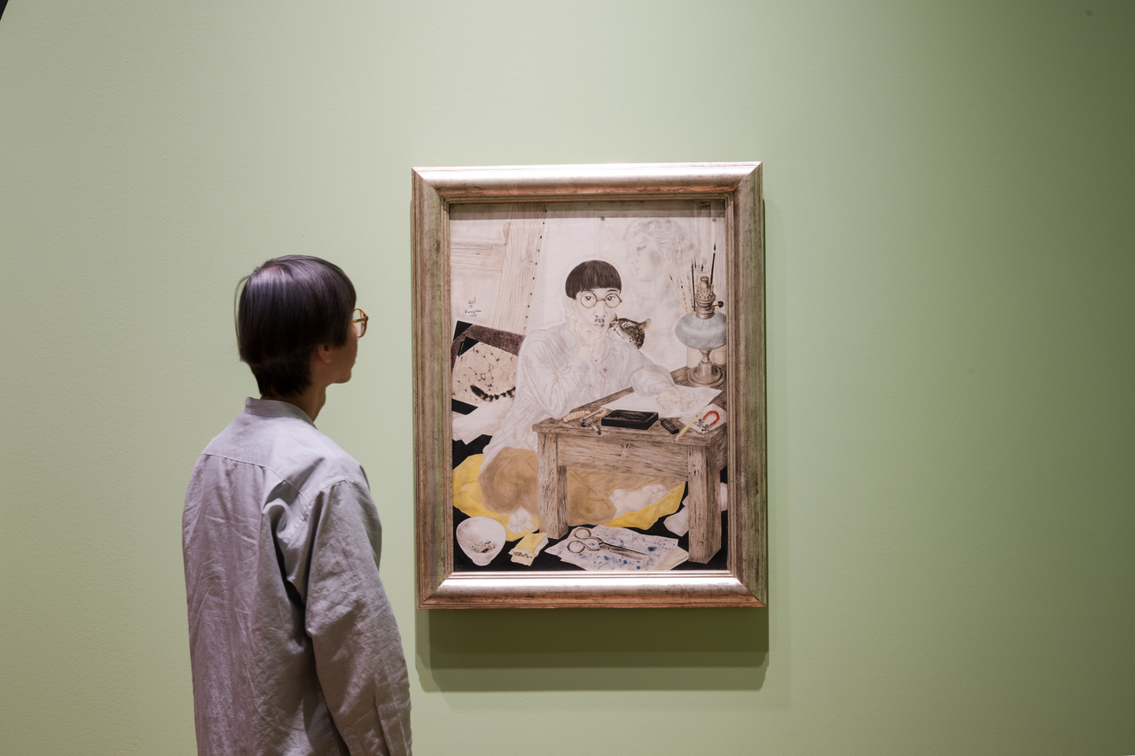 A visitor views Tsuguharu Foujita's "Self-Portrait with Cat" (1926) at National Gallery Singapore's exhibition "City of Others: Asian Artists in Paris, 1920s-1940s." (National Gallery Singapore)