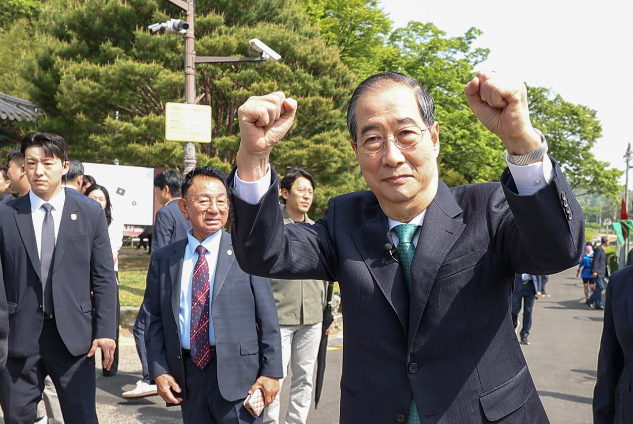 Former Prime Minister Han Duck-soo clenches his fists as he greets his supporters during a visit to former President Park Chung-hee's birthplace in Gumi, 200 kilometers southeast of Seoul, on Thursday. (Yonhap)