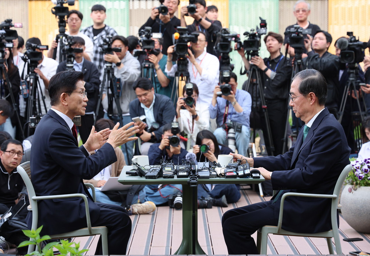 People Power Party presidential candidate Kim Moon-soo, left, speaks with ex-Prime Minister Han Duck-soo during a meeting held at a coffee shop in the National Assembly in western Seoul on Thursday. Yonhap