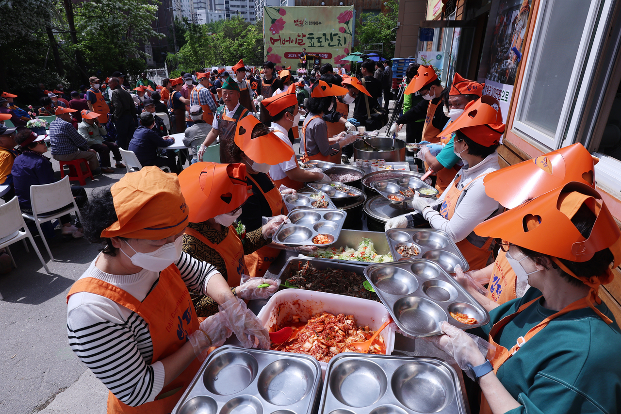 Volunteers serve free lunch during a Parents’ Day event held in Dongdaemun-gu, Seoul, Thursday. (Yonhap)