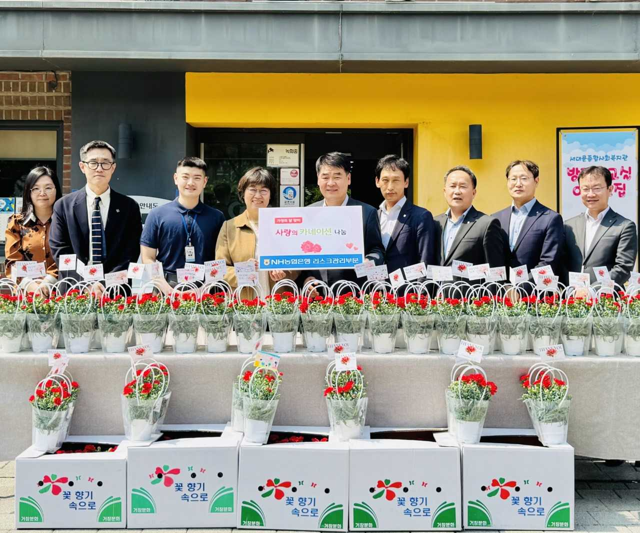 양재영(왼쪽에서 다섯번째) NH농협은행 리스크관리부문 부행장과 임직원들이 7일 가정의 달을 맞아 서대문종합복지관에 카네이션을 전달했다. [NH농협은행]