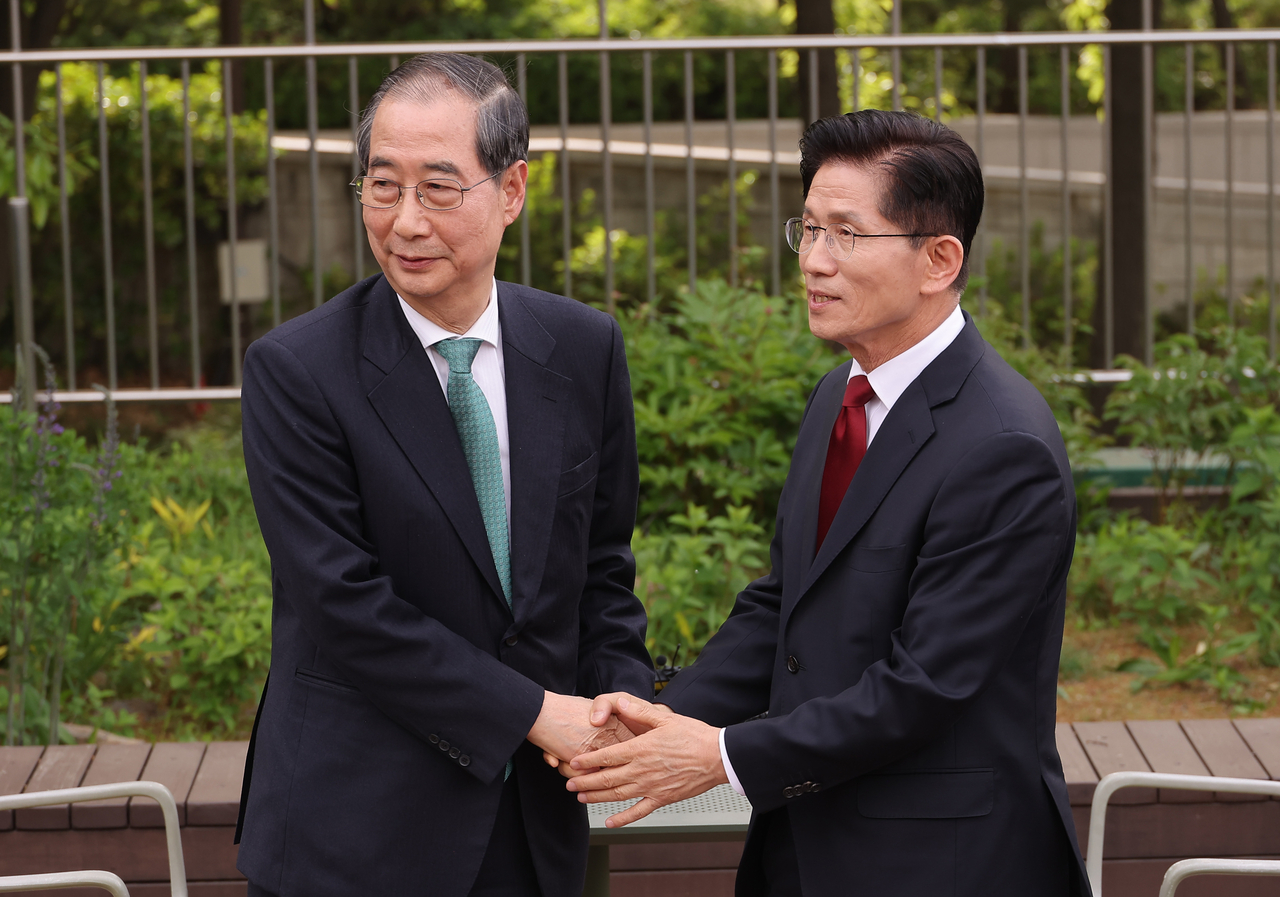 김문수 국민의힘 대선후보(오른쪽)와 한덕수 무소속 대선 예비후보가 8일 서울 국회 사랑재에 위치한 커피숍에서 만나 악수하고 있다. [연합]