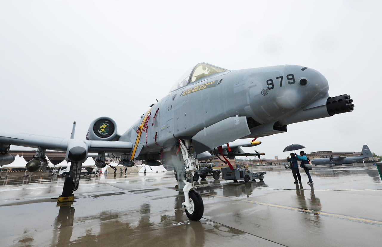 An A-10 attack aircraft stands on display on the wet flight line as visitors tour the air base. (Yonhap)