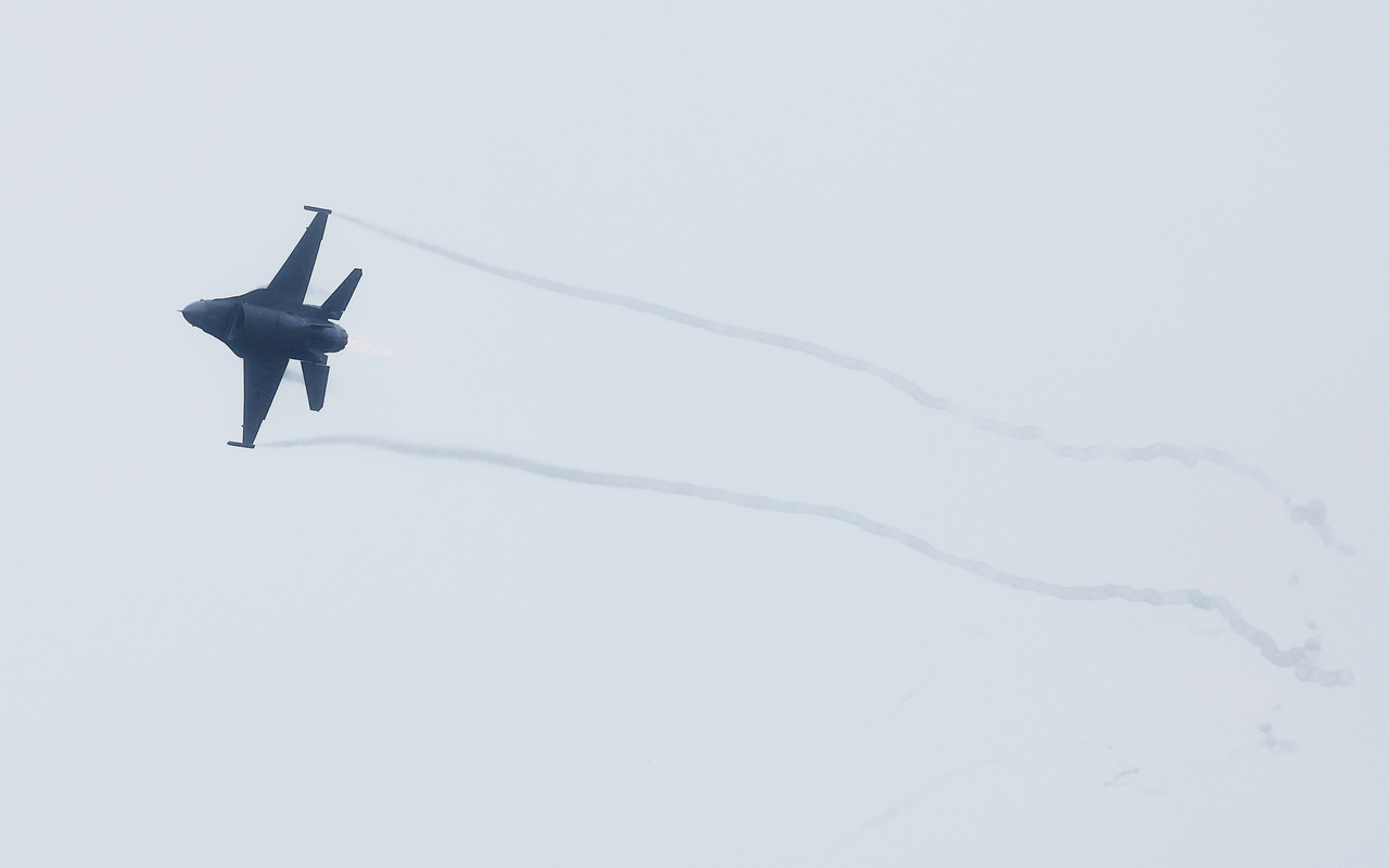 Vapor trails stream from a US Air Force F-16 as it performs an aerial maneuver during rehearsal flights at Osan Air Base. (Yonhap)