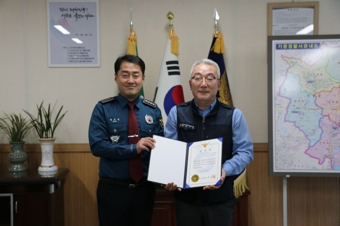 Bus driver Lee (right) poses after receiving a certificate of appreciation for his recent assistance in catching a sex offender, in this photo provided by the Busan Gijang Police Station to the local media. (Busan Gijang Police Station)
