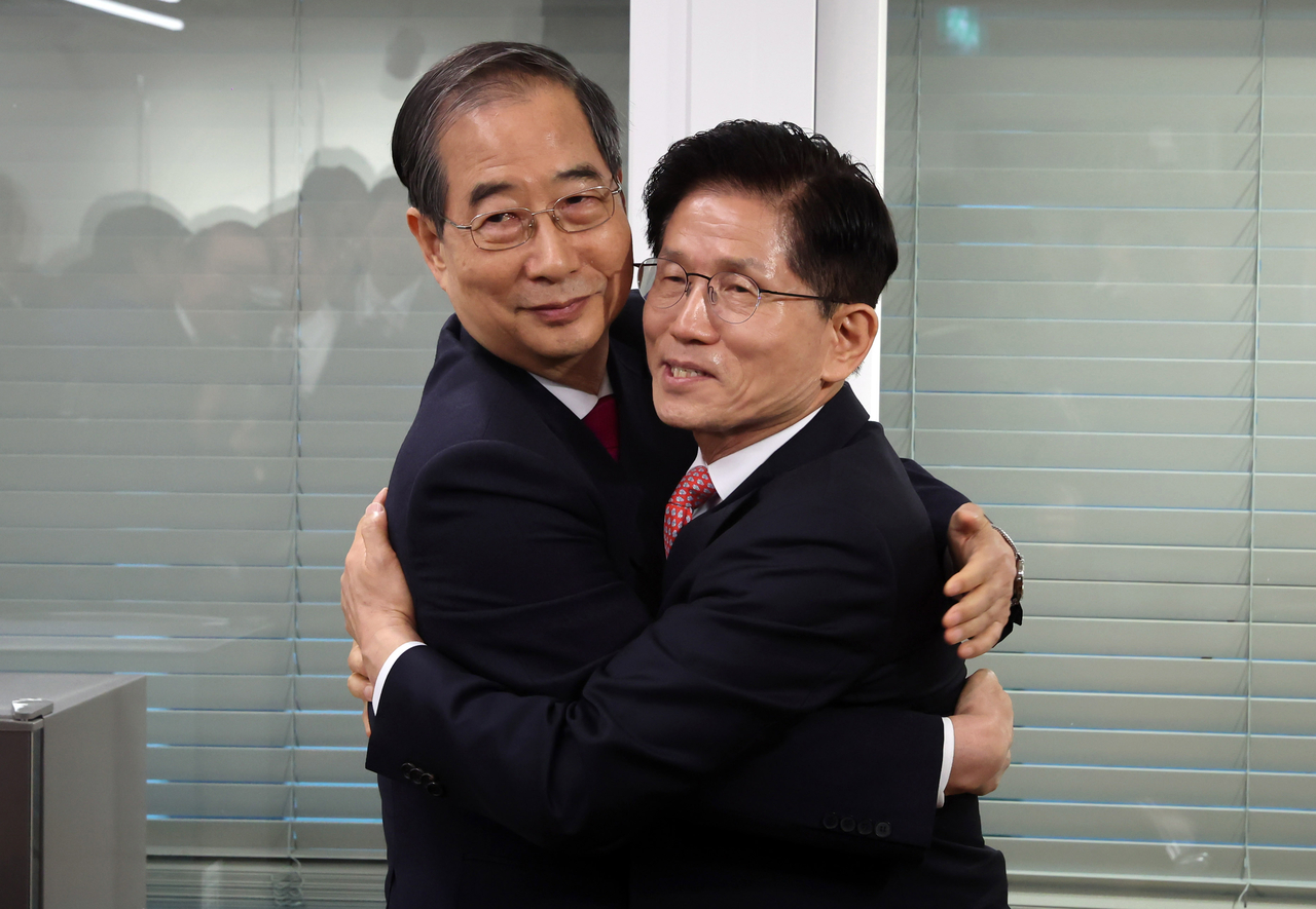 People Power Party's presidential nominee Kim Moon-soo (right) and former Prime Minister Han Duck-soo hug each other on Sunday (Pool photo via Yonhap)