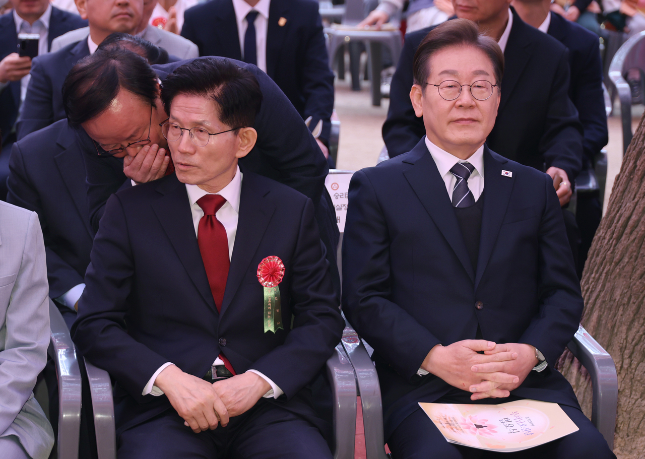 Democratic Party presidential candidate Lee Jae-myung (right) listens to People Power Party presidential candidate Kim Moon-soo at a temple in Seoul during an event marking Buddha's Birthday on May 5. (Yonhap)