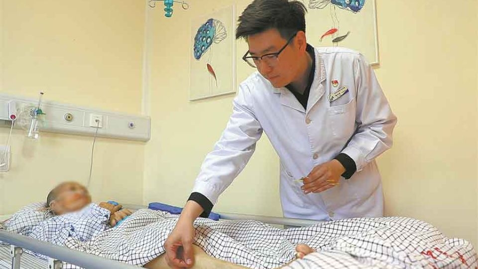 Oncology doctor Han Danyang (right) gives acupuncture treatment to a patient at Gulou Hospital of Traditional Chinese Medicine in Beijing.   (China Daily)