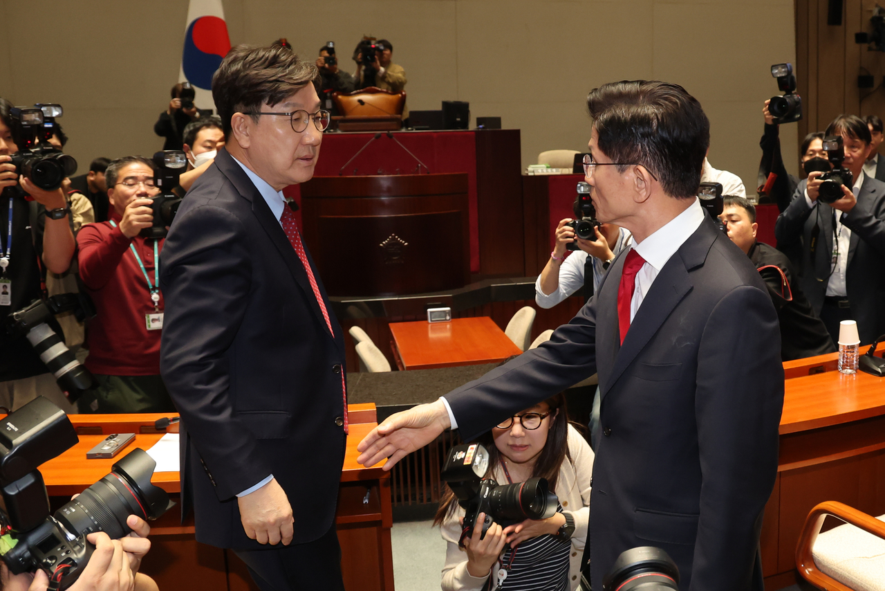 Kim walks out of a meeting of People Power Party lawmakers mid-session on May 9 at the National Assembly in Seoul, out of protest against remarks by floor leader Rep. Kwon Seong-dong (left), who urged him to merge his campaign with Han's immediately. (Yonhap)
