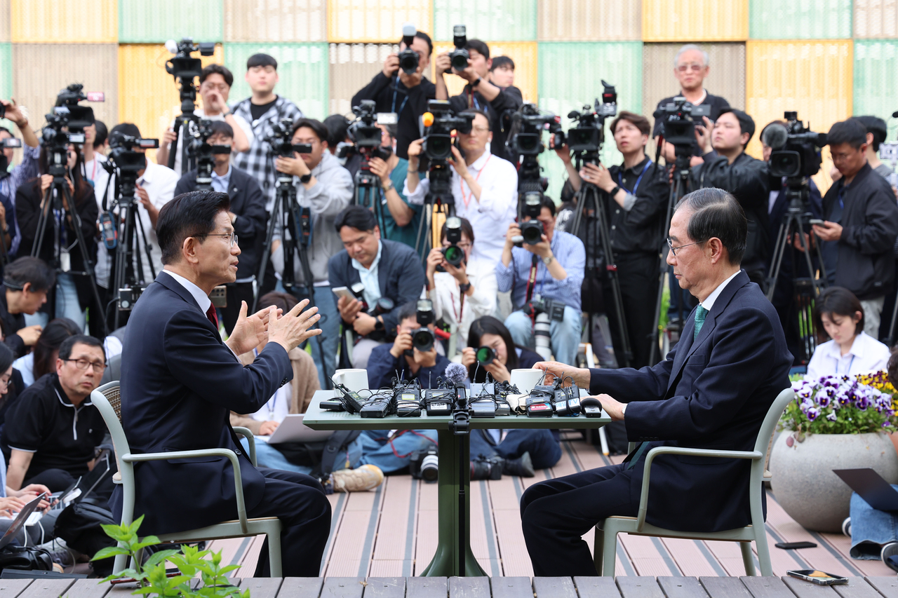 Han (right), then an independent presidential candidate, and People Power Party presidential candidate Kim meet for talks at a cafe in the National Assembly in Seoul on May 8. (Yonhap)