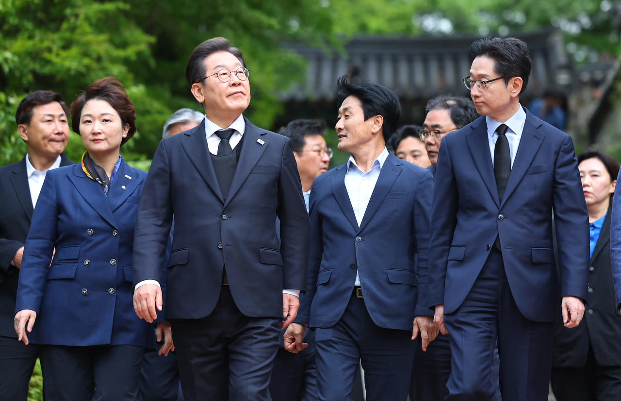 영남 신라벨트 골목골목 경청투어에 나선 더불어민주당 이재명 대선 후보가 10일 경남 남해군 설천면 충렬사에서 이순신 장군 참배를 마친 뒤 이동하고 있다. <연합>
