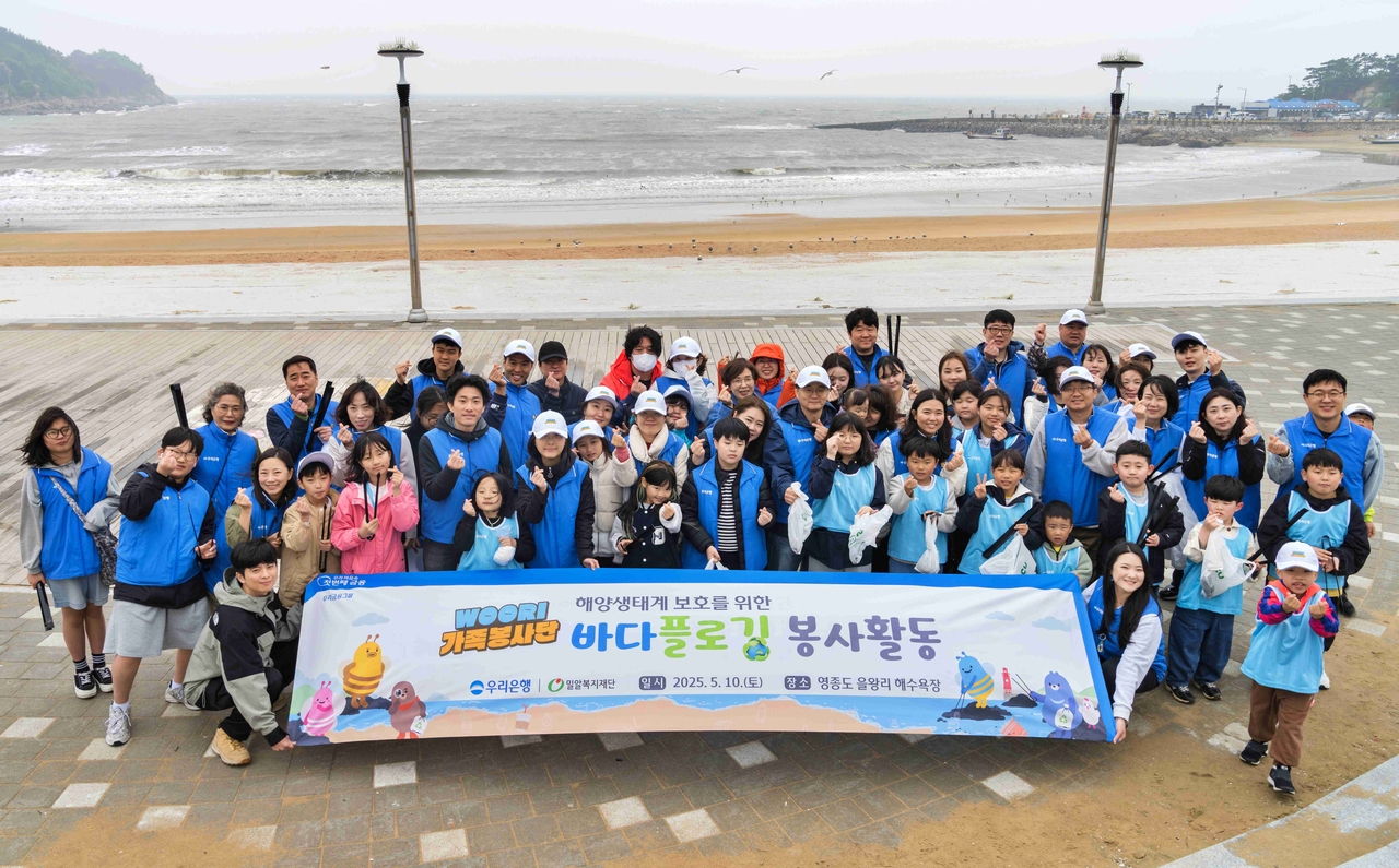 WOORI가족 봉사단이 지난 10일 을왕리해수욕장에서 플로깅 봉사를 끝내고 기념촬영을 하고 있다. [우리은행 제공]