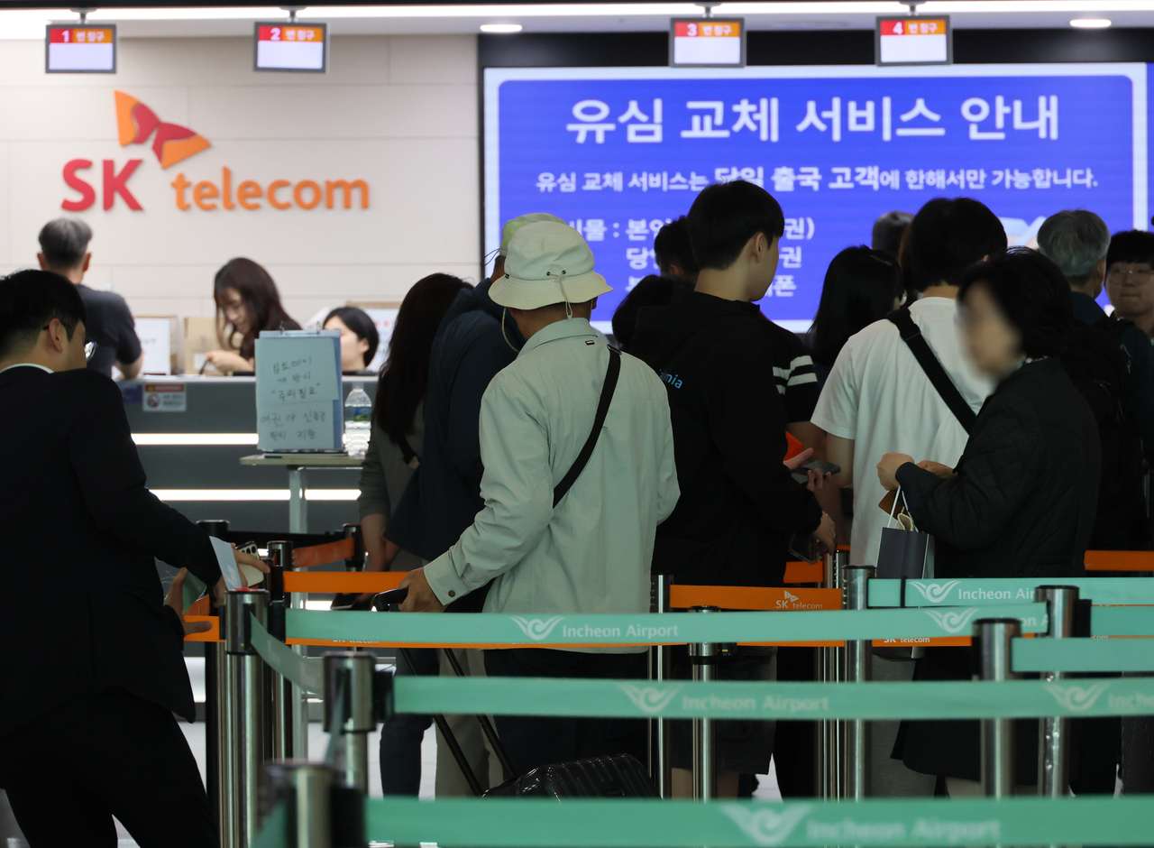 최근 인천국제공항 2터미널 출국장 내 SK텔레콤 로밍센터에서 출국자들이 유심 교체를 위해 줄을 서고 있다.  [연합]
