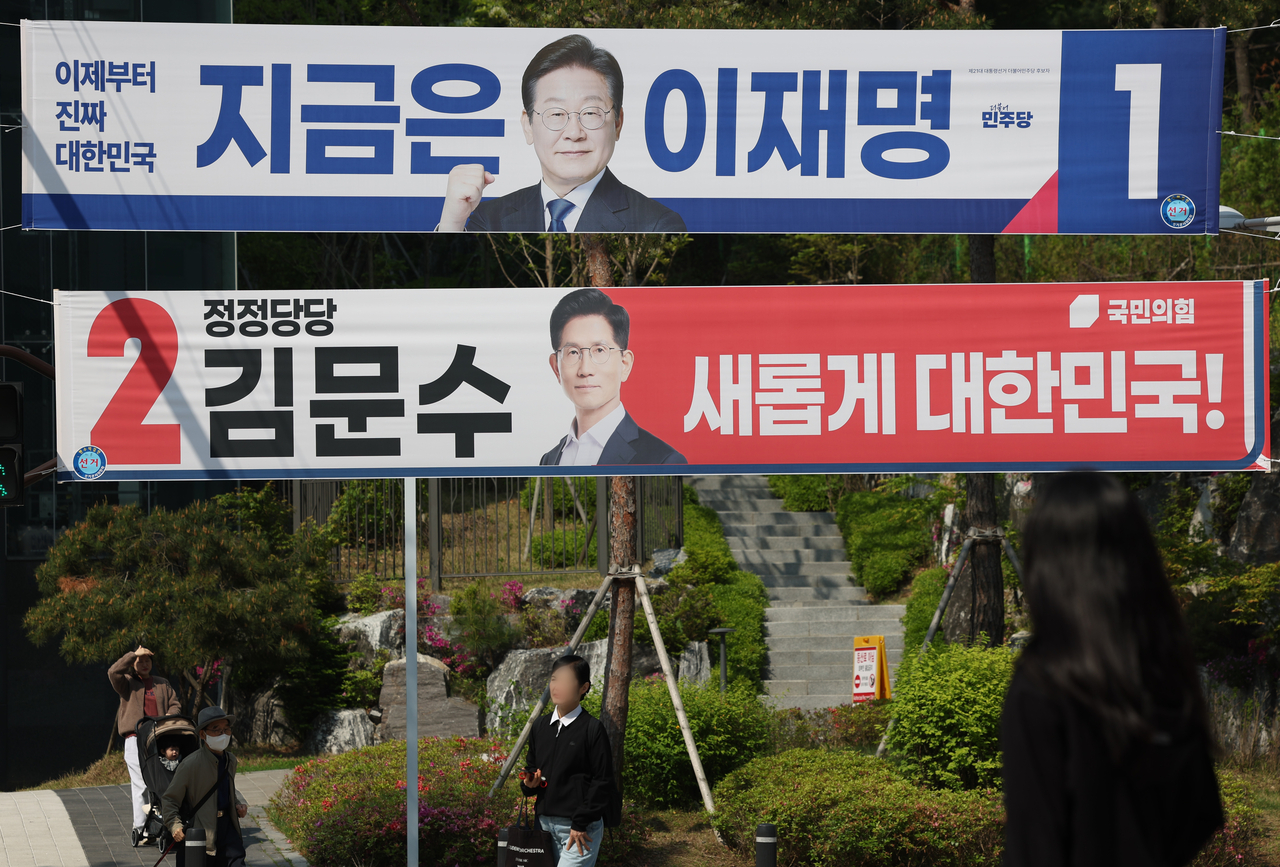 Banners for Democratic Party of Korea candidate Lee Jae-myung (top) and People Power Party candidate Kim Moon-soo hang on a street in Seodaemun-gu, Seoul, on Monday, the first official day of the presidential election campaign period. (Yonhap)