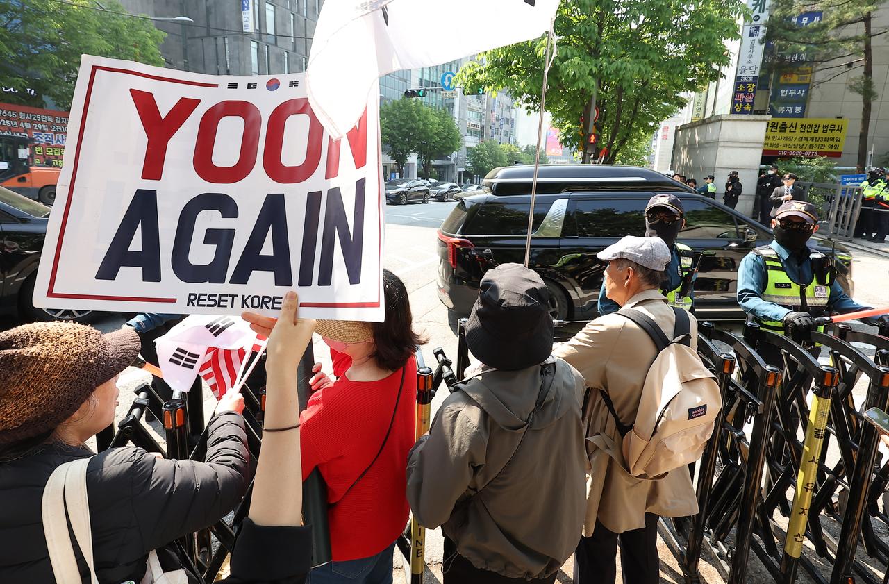 Supporters waving banners and signs await former President Yoon Suk Yeol's arrival at the Seoul Central District Court in Seoul on Monday. (Yonhap)
