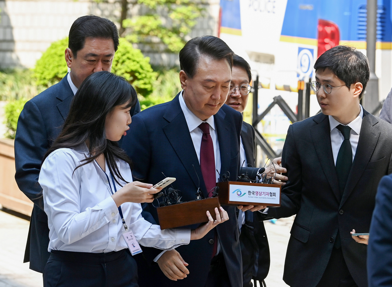 윤석열 전 대통령이 12일 서울 서초구 중앙지방법원에서 열린 내란 우두머리 혐의, 직권남용 권리행사방해 혐의 사건 3차 공판에 출석, 취재진의 질문을 받으며 이동하고 있다. 2025.5.12 [사진공동취재단] [연합]