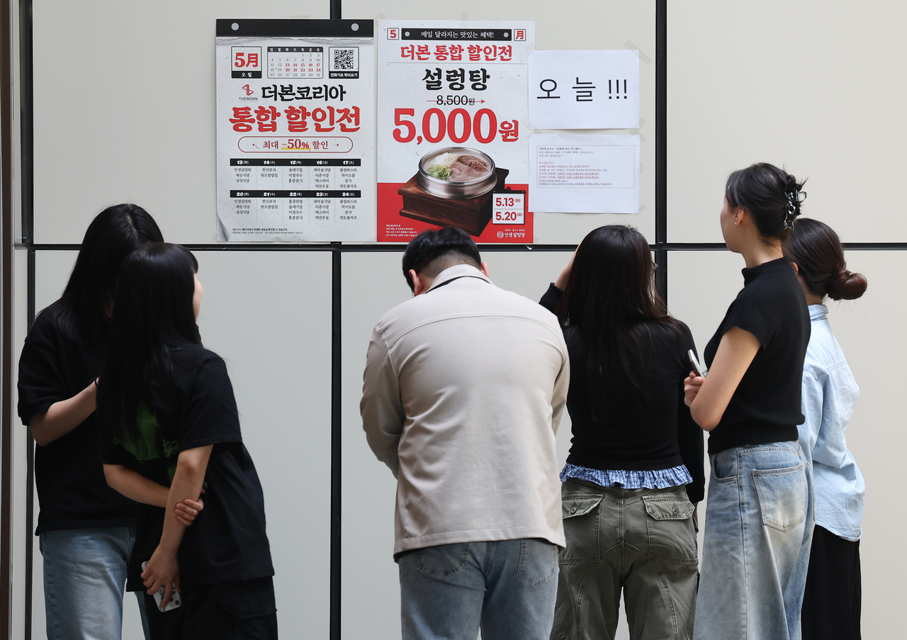 Customers look at promotional posters at TheBorn Korea’s Insaeng Seolleongtang restaurant in Seoul on Tuesday, the first day of a discount campaign launched by the franchiser. (Yonhap)