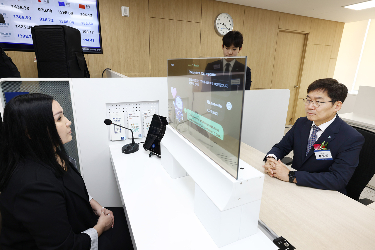 김형일(오른쪽) IBK기업은행 전무이사가 13일 경기도 안산시 기업은행 안산외국인금융센터에서 실시간 통번역서비스 시스템을 시연하고 있다. [기업은행 제공]