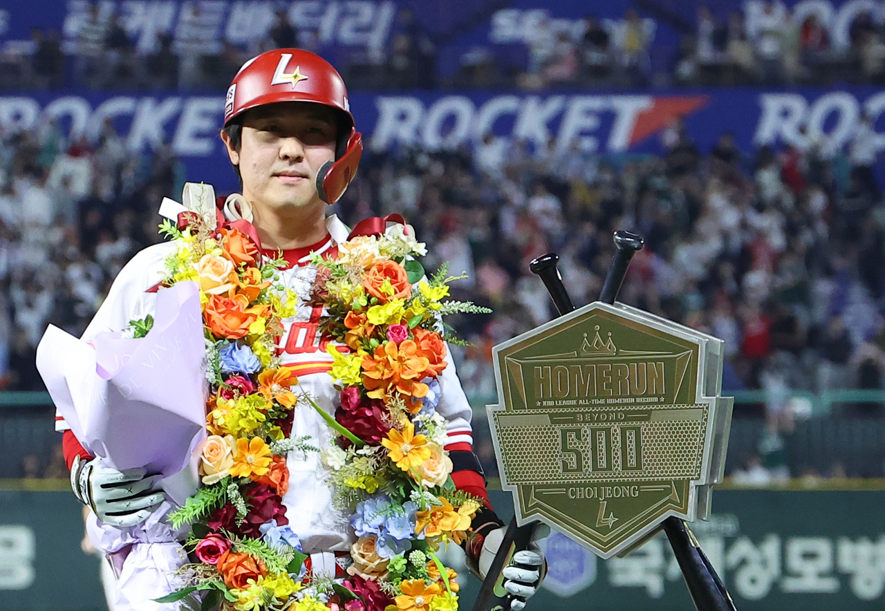최정이 13일 NC 다이노스전에서 KBO 리그 최초 통산 500홈런을 친 뒤 기념 조형물과 함께 포즈를 취하고 있다. [연합]