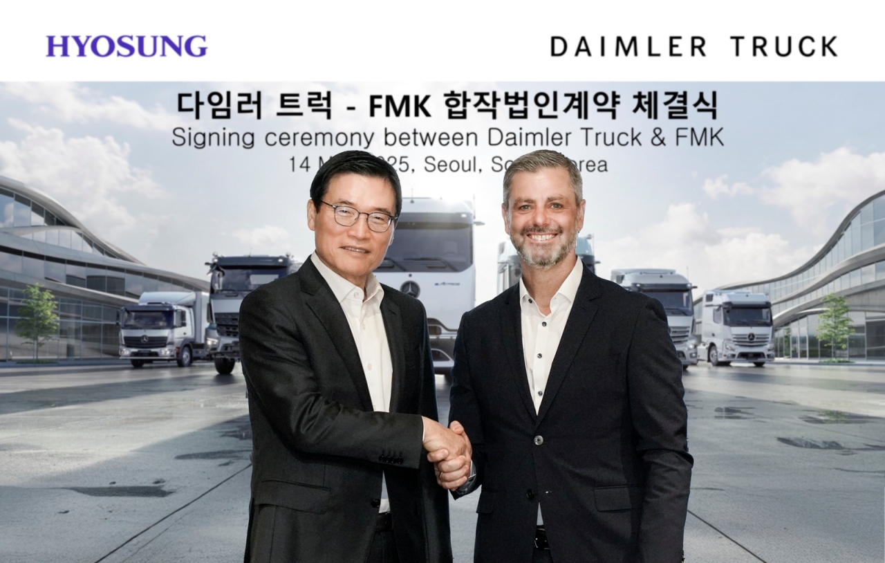 FMK Korea President Kim Gwang-chul (left) and Daimler Truck Southeast Asia CEO Harald Schmid pose for a photo during the signing ceremony for a strategic joint venture in Seoul on Wednesday. (Daimler Truck)