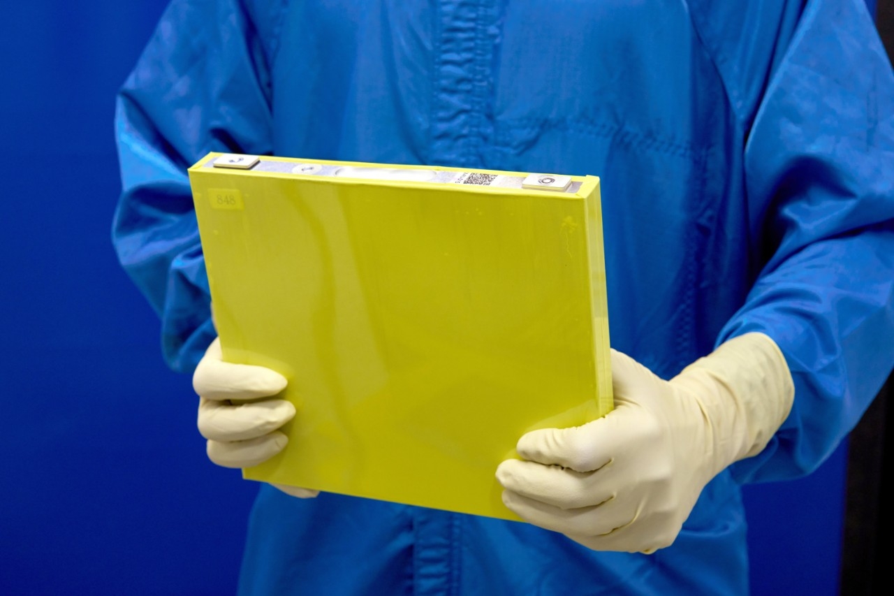 An employee holds a full-size prototype lithium manganese-rich battery cell at the General Motors Wallace Battery Cell Innovation Center in Warren, Michigan. (Steve Fecht/General Motors)