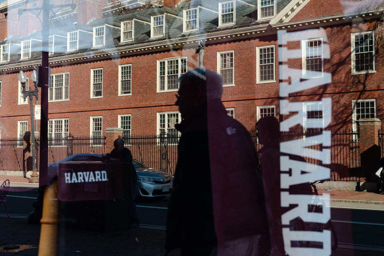 Harvard University is reflected in the window of a merchandise store across the street from the school in April. (AFP-Yonhap)