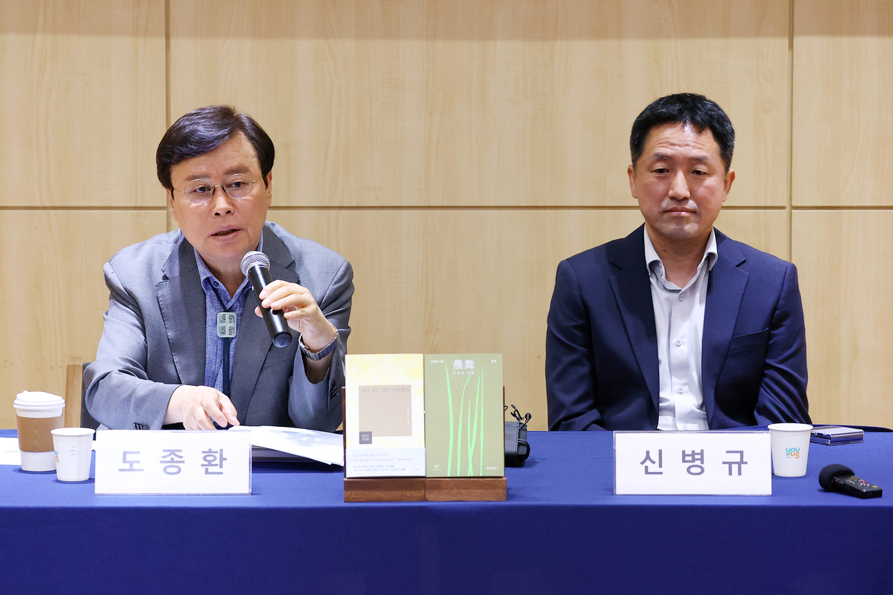 Poet Do Jong-hwan (left) and Shin Kyung-rim's second son, Shin Byung-gyu, attend a press conference on Wednesday. (Yonhap)