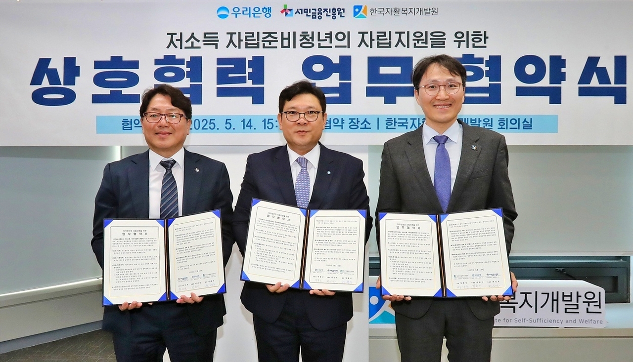 박종인(가운데) 우리은행 부행장이 지난 14일 한국자활복지개발원 본원에서 최인호(왼쪽) 서민금융진흥원 부원장, 정해식 한국자활복지개발원 원장과 업무협약을 체결하고 기념촬영을 하고 있다. [우리은행 제공]