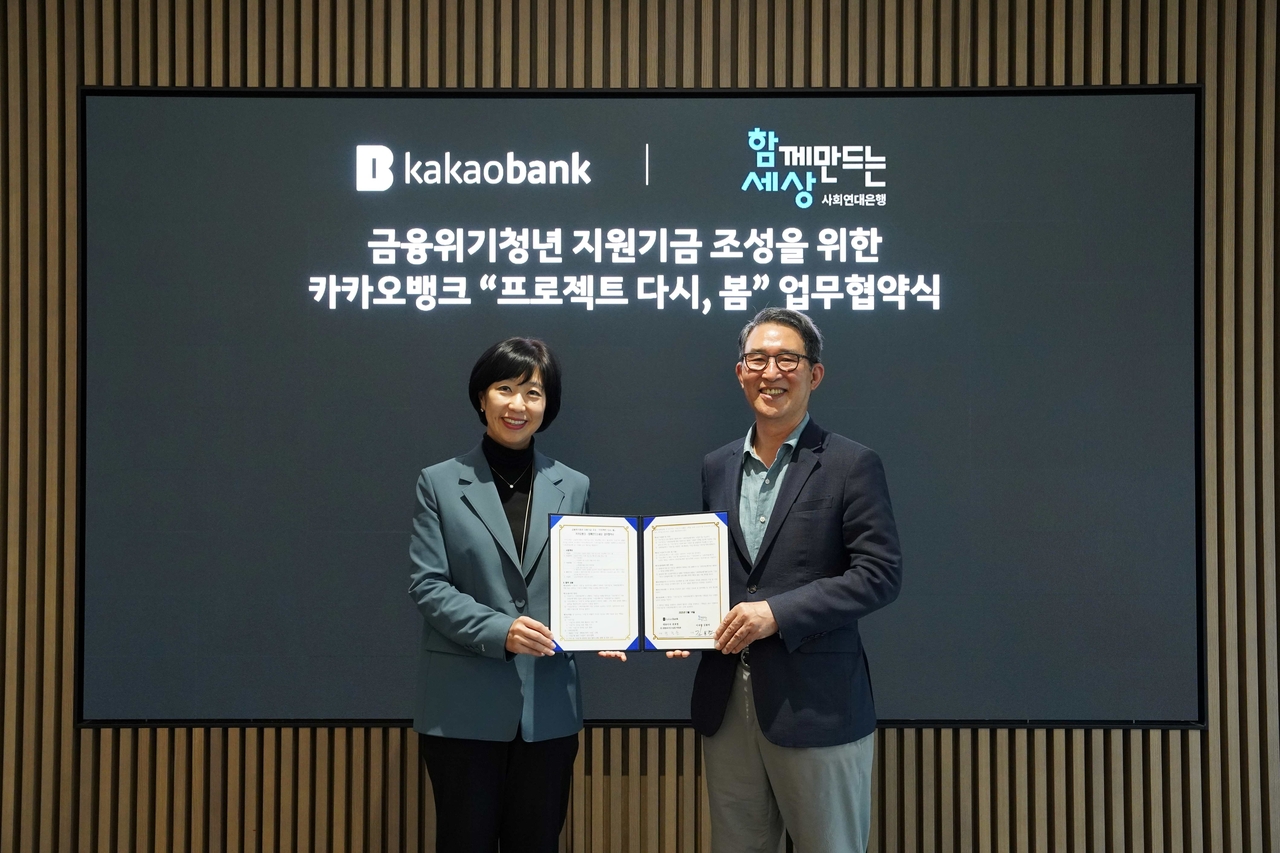 박정윤(왼쪽) 카카오뱅크 컴플라이언스실장과 김용덕 사회연대은행 이사장이 협약식에서 기념촬영하고 있다.  [카카오뱅크 제공]