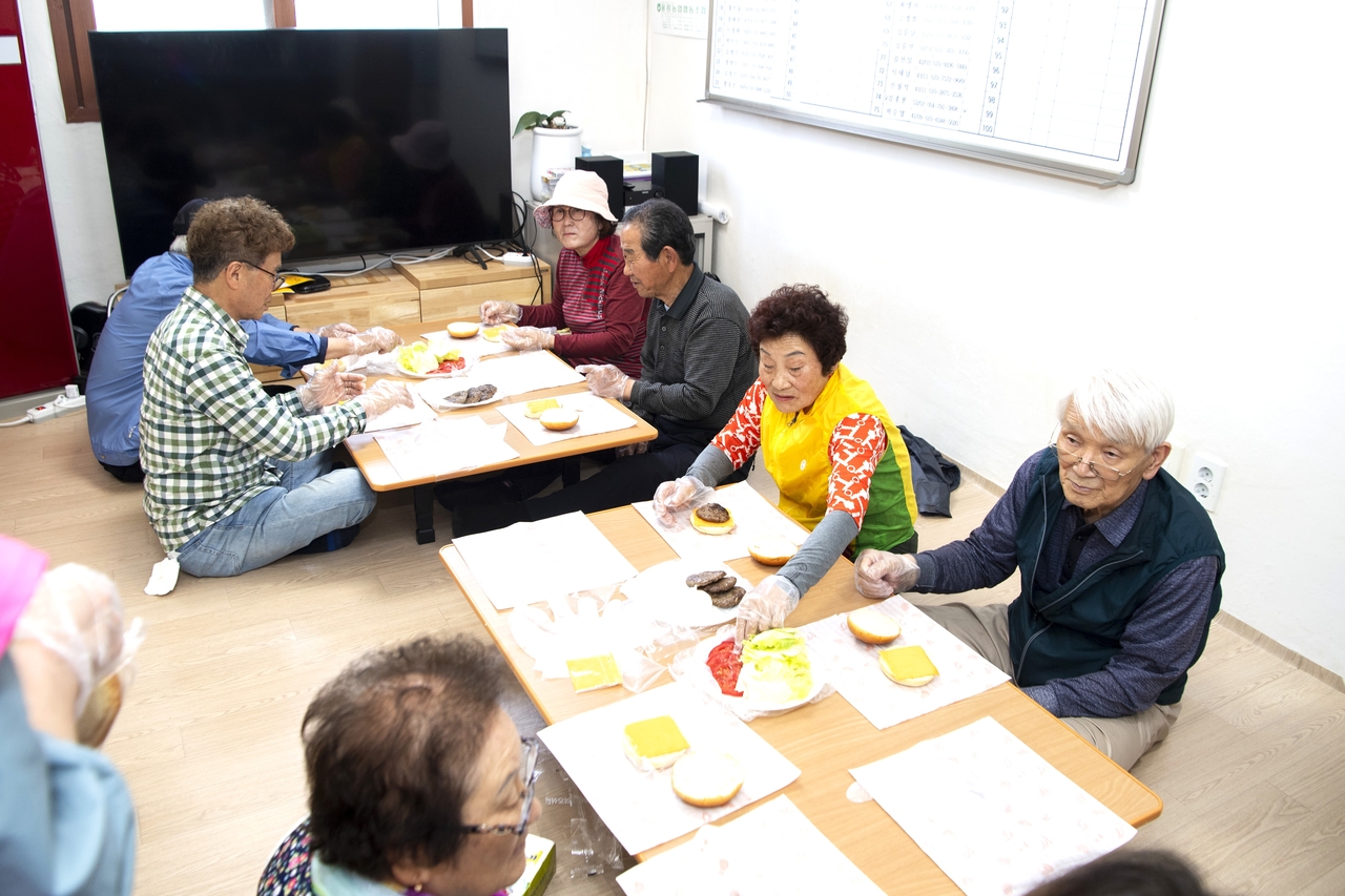 울릉군의 ‘경로당 행복선생님’ 지원 사업일환으로 어르신들이  경로당에서 햄버거 만들기를 하고 있다[울릉군제공]