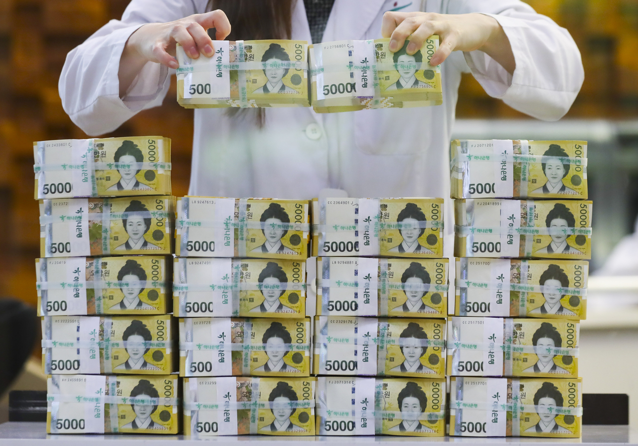 A Bank of Korea official displays samples of 50,000 won bill in this 2023 file photo. (Herald DB)