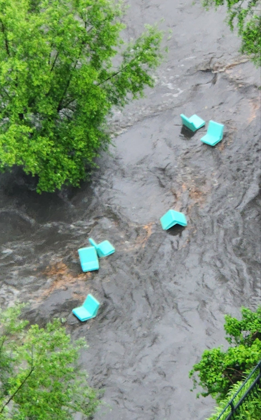 Chairs from the Cheonggyecheon open-air library are seen being swept downstream by rising water following heavy rain. (Yonhap)