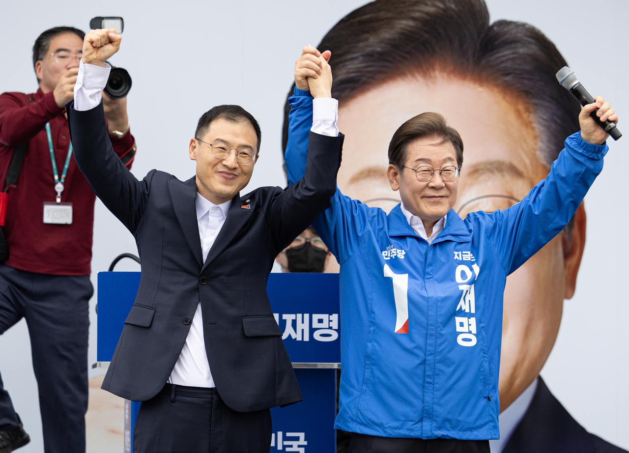 더불어민주당 이재명 대선후보가 16일 전북 익산시 익산역 동부광장에서 열린 유세에서 무소속 김상욱 의원과 손을 들어 인사하고 있다. 연합뉴스
