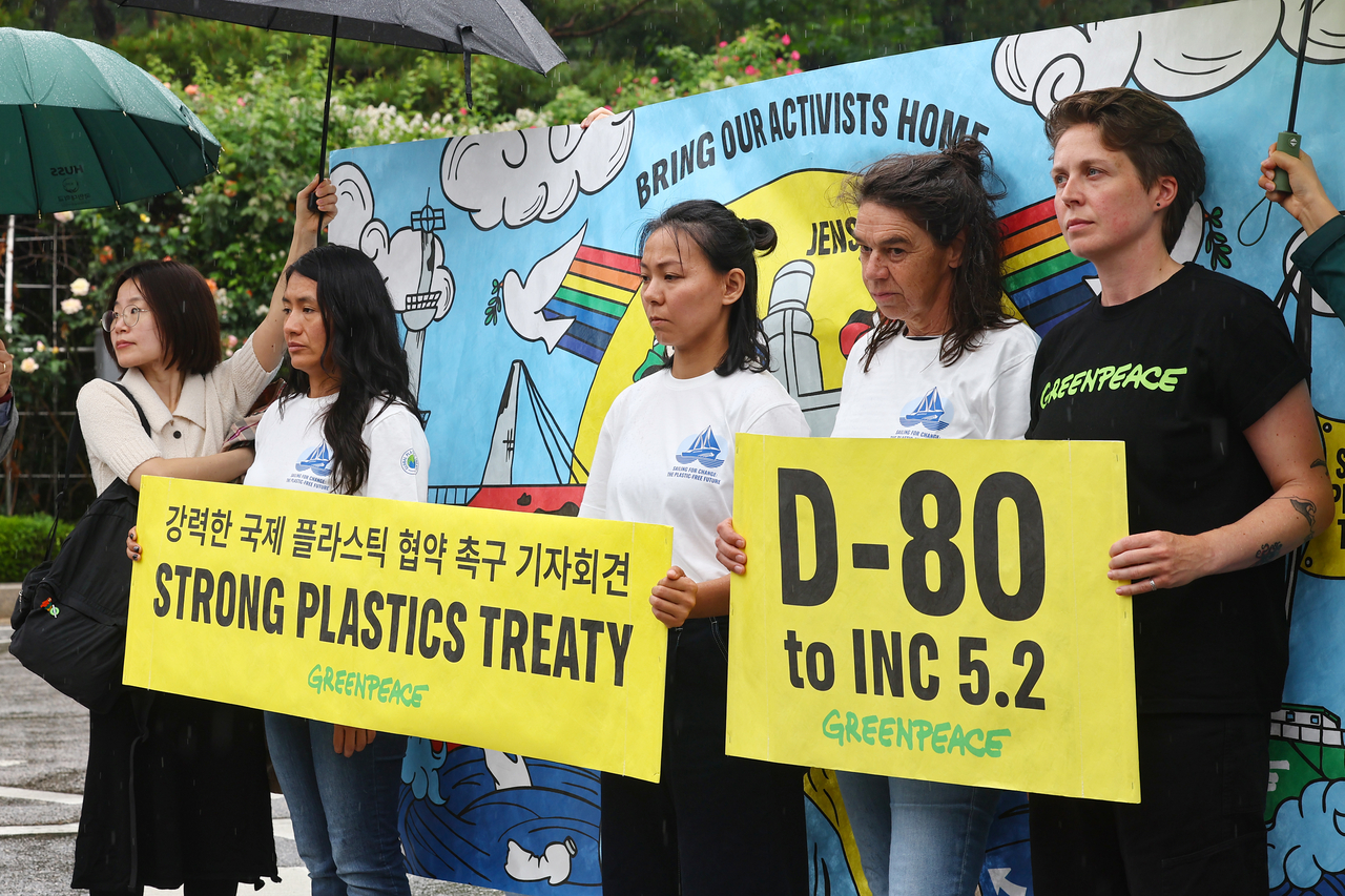 Four Greenpeace activists holding banners calling for a strong plastics treaty during their press conference held at the Seoul Central District Court, Seocho-gu, Seoul, on Friday. (Yonhap)
