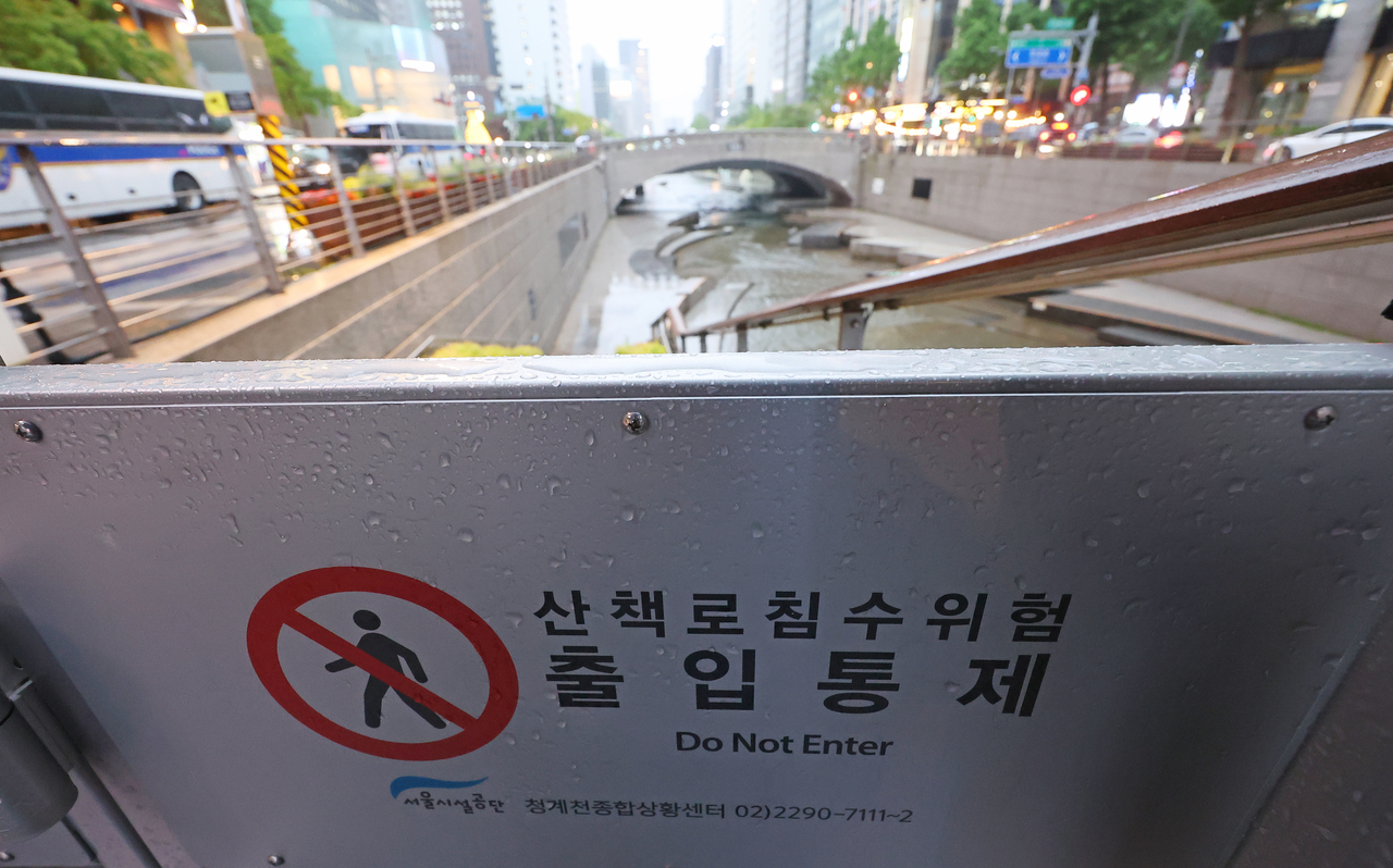 서울 대부분 지역에 호우주의보가 내려진 16일 서울 청계광장 인근 청계천 산책로 입구 출입이 통제되고 있다. [연합]