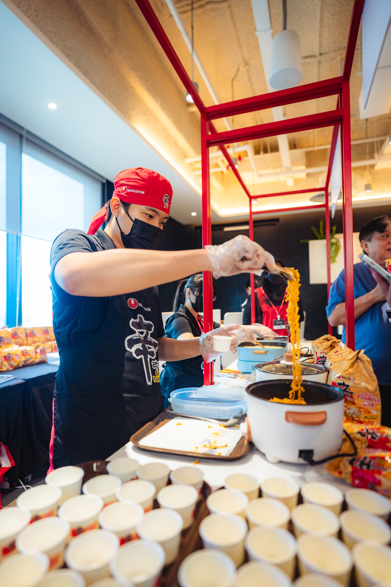 A Nongshim staff member prepares Shin Ramyun Toomba for visitors during a promotional event in Malaysia. (Nongshim)