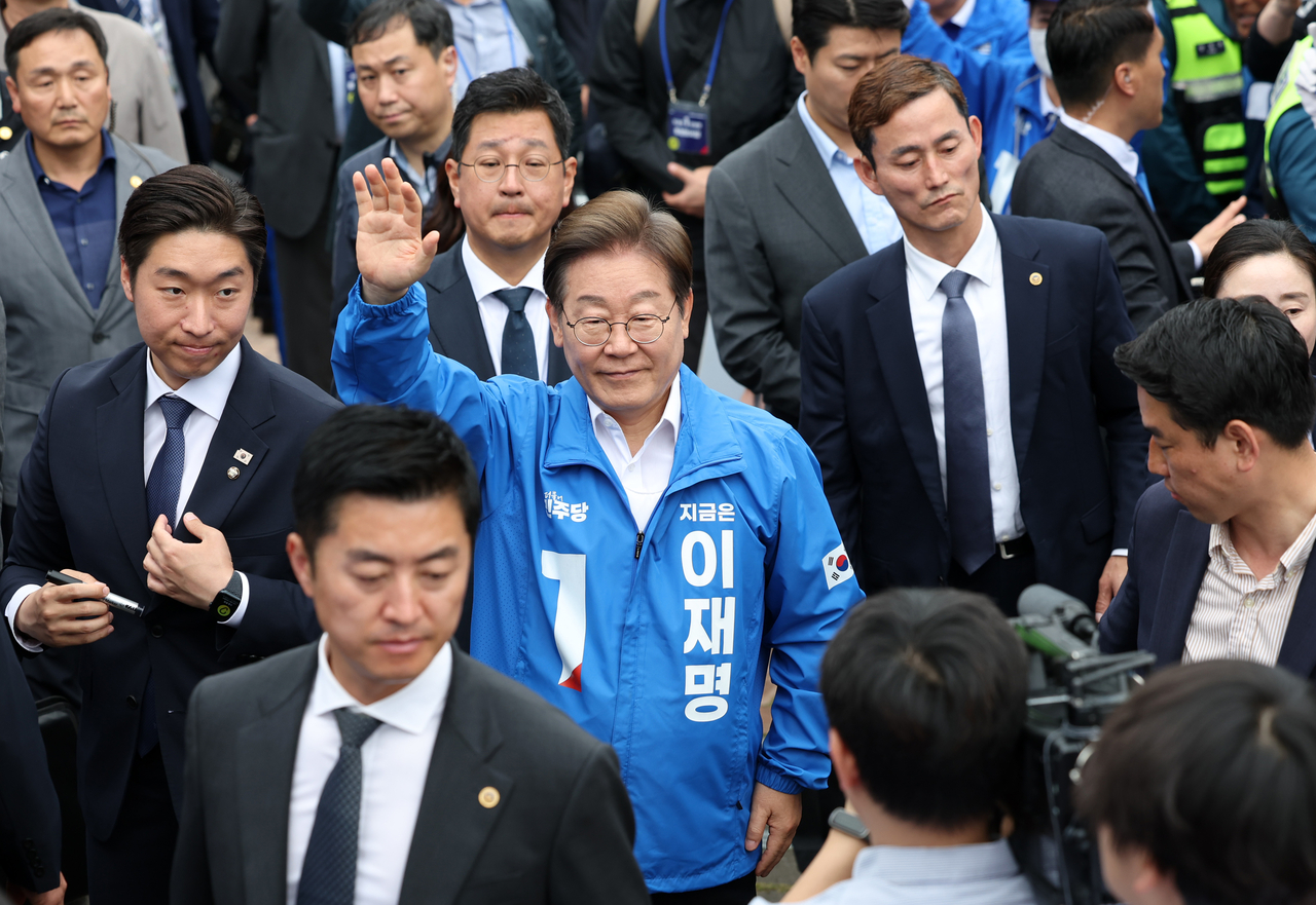 Lee Jae-myung, the presidential candidate of the Democratic Party of Korea, is surrounded by his security team as he heads to the podium for a public address on Friday in Gunsan, North Jeolla Province, during his presidential campaign. (Yonhap)